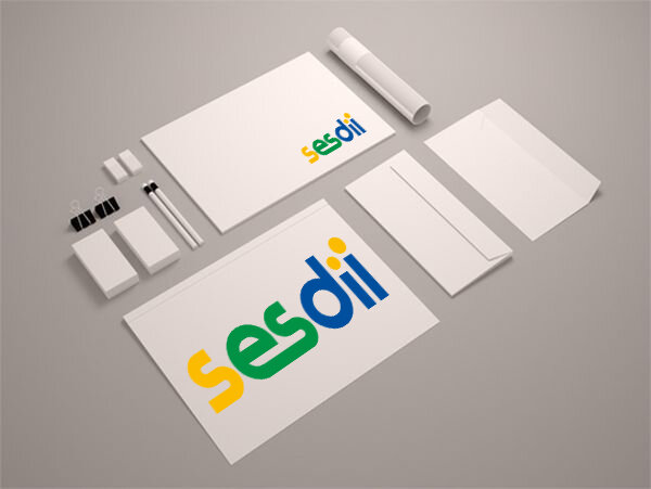 Set de papelería que incluye tarjetas de visita, carpetas y blocs de notas con el logo "sesdii" en verde y amarillo sobre fondo gris para fines de marketing.